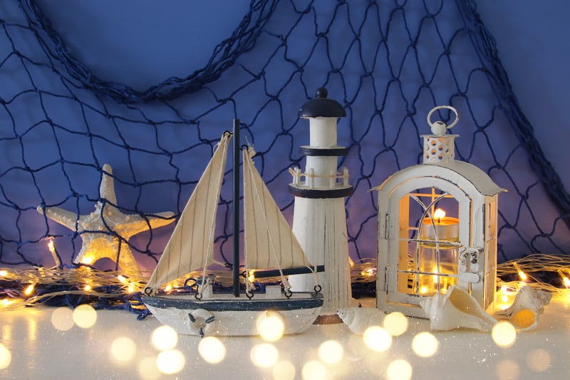 Magical Lantern With Candle Light And Wooden Boat On The Shelf. Nautical Concept